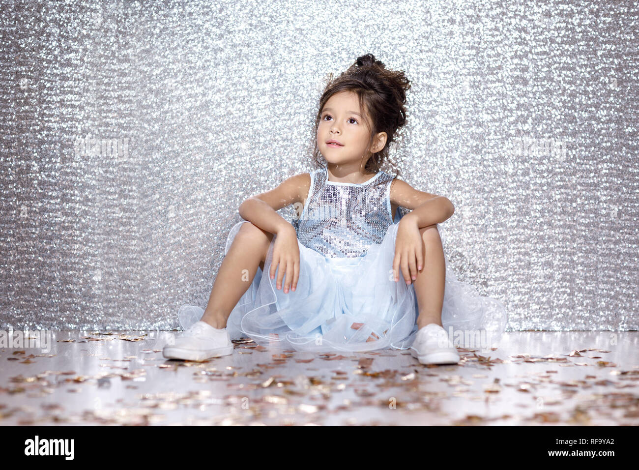 little child girl in dress sitting on the floor with confetti Stock ...