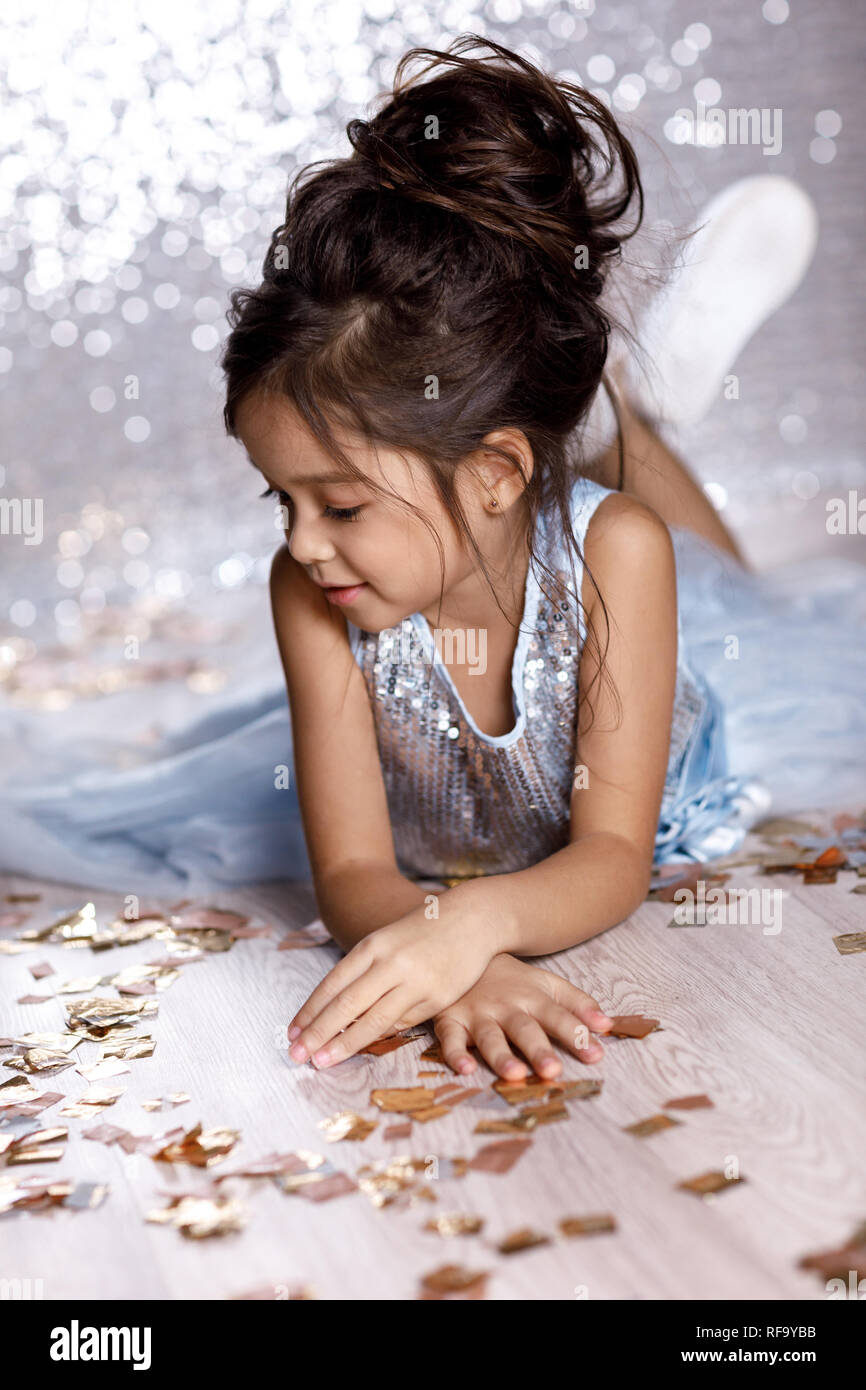 little girl in blue dress sitting on the floor with confetti Stock ...