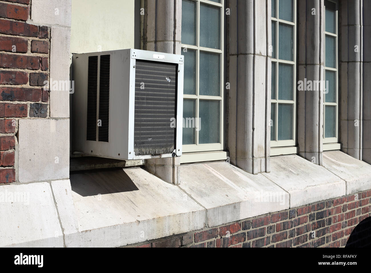 Window Air Conditioner unit on old brick building Stock Photo
