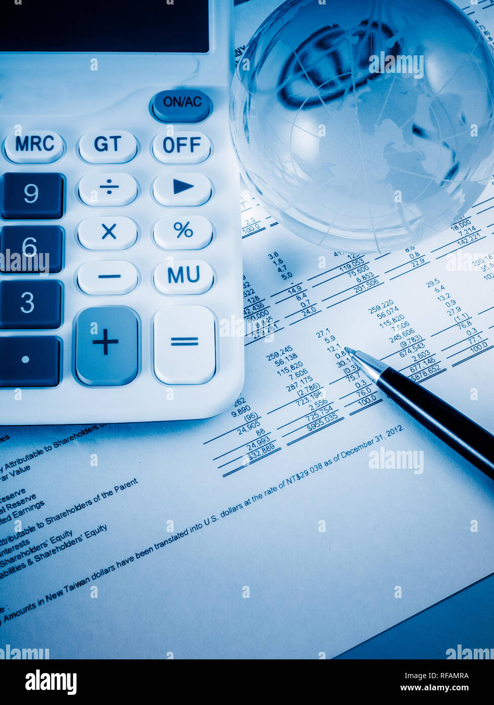 A close-up shot of a calculator. A printed balance sheet and a pen are ...
