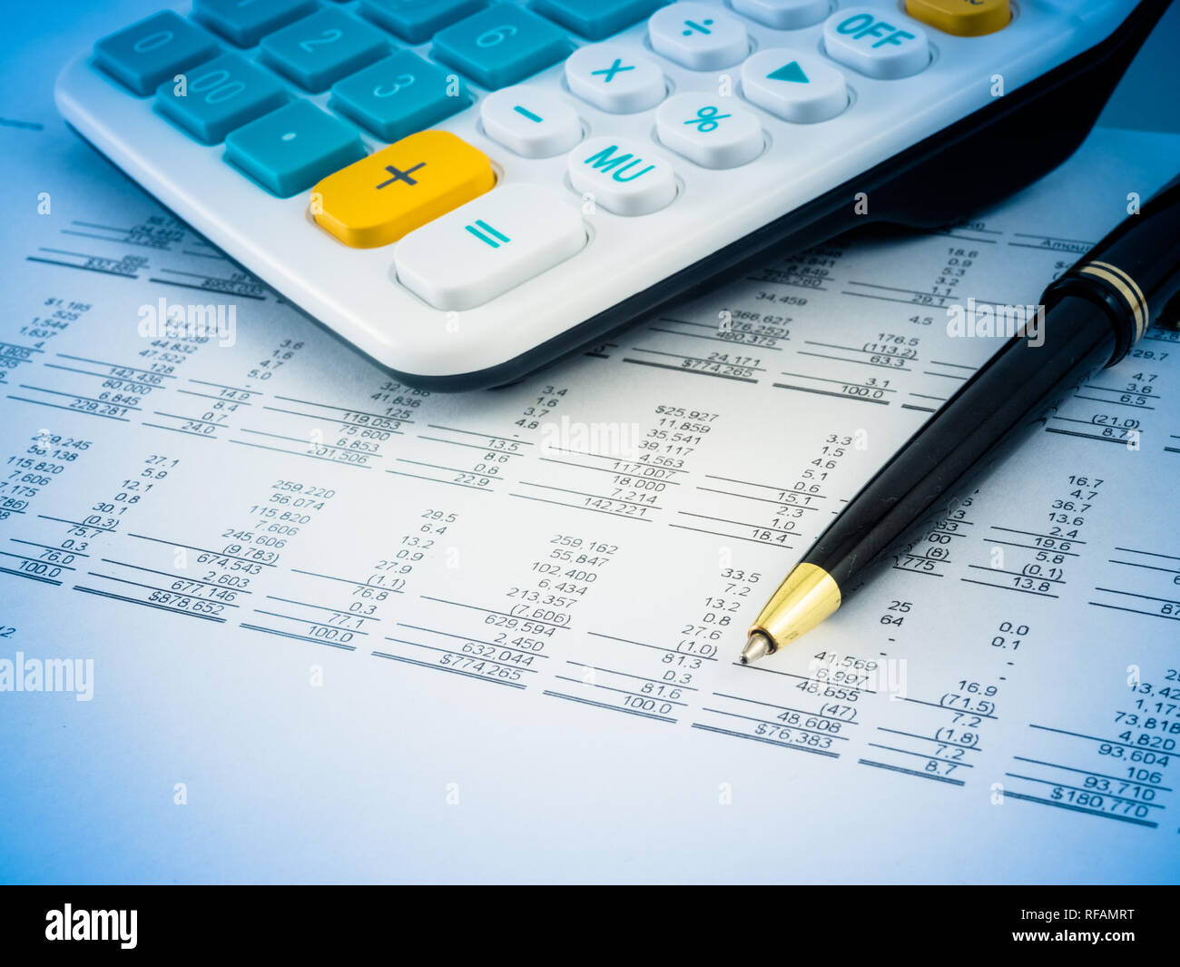 A close-up shot of a calculator. A printed balance sheet and a pen are ...