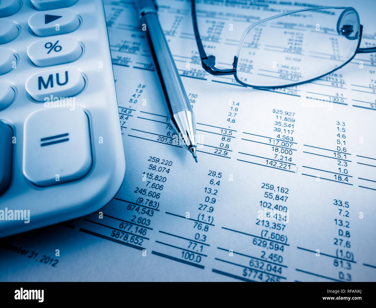 A close-up shot of a calculator. A printed balance sheet and a pen are ...