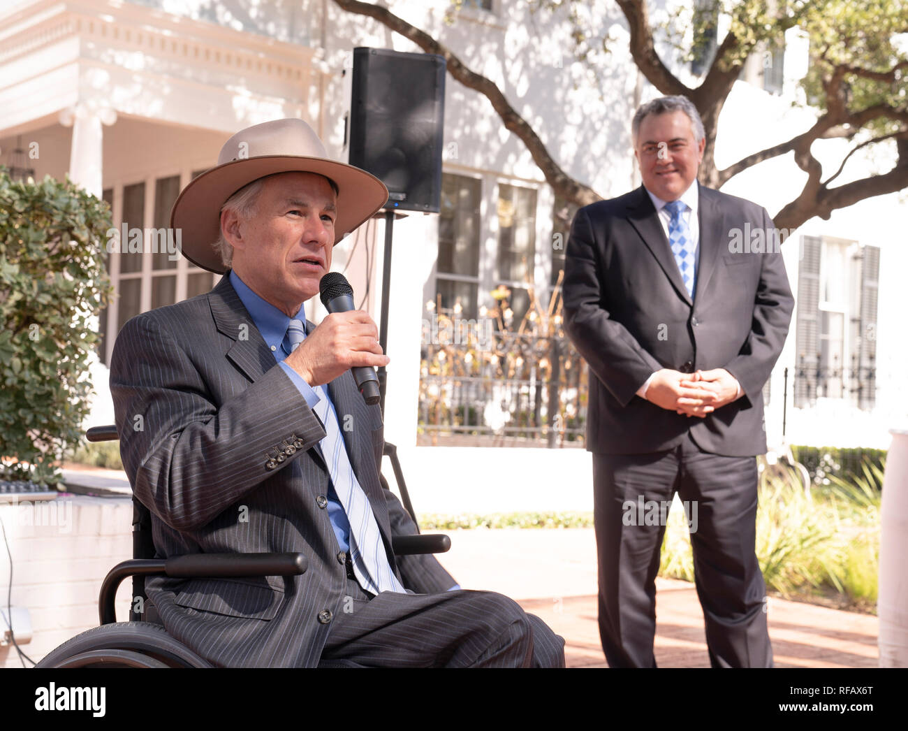 Joe Hockey, Australia's ambassador to the United States, listens to Texas Gov. Greg Abbott (in wheelchair) during the Great Mates Australia-Texas Barbecue at the Governor's Mansion. Abbott and Hockey worked to strengthen ties between the allies discussing agriculture and high tech before eating Australian Vegemite burnt ends and HeartBrand Akaushi beef. Stock Photo