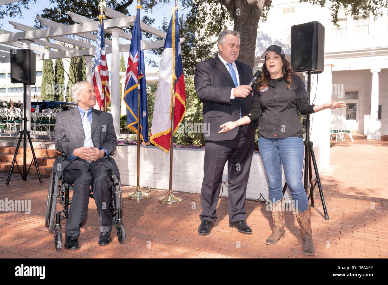 Joe Hockey, Australian ambassador to the United States, talks with barbecue chef and cookbook author Jess Pryles of Melbourne and Austin, TX, as he visits with Texas Gov. Greg Abbott (in wheelchair) during the Great Mates Australia-Texas Barbecue at the Governor's Mansion. Abbott and Hockey worked to strengthen ties between the allies discussing agriculture and high tech before eating Australian Vegemite burnt ends and HeartBrand Akaushi beef. Stock Photo