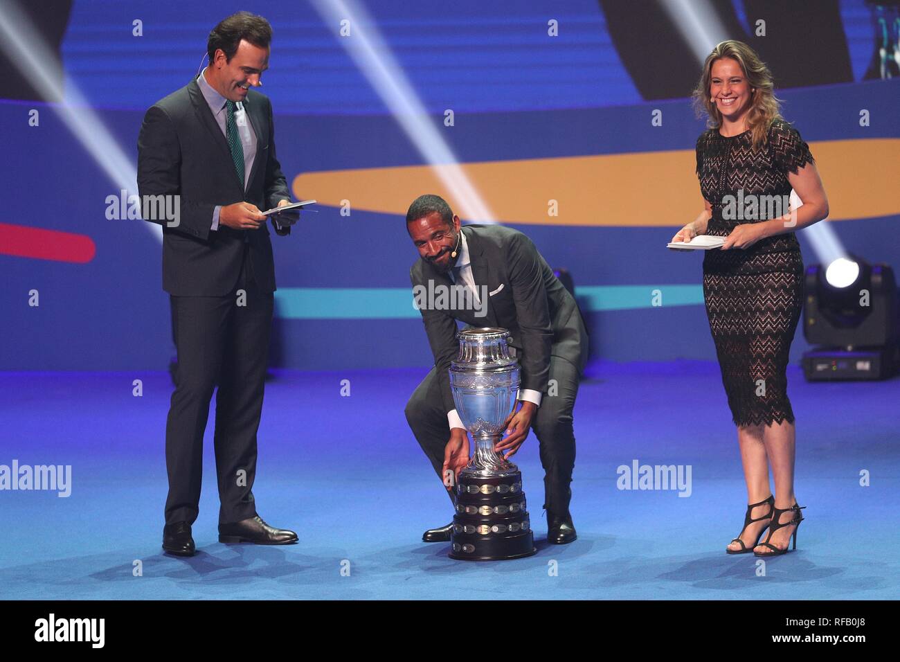 Rio De Janeiro, Brazil. 24th Jan, 2019. Chile's football player Jean Beausejour (C) puts down the trophy during the official draw ceremony of the CONMEBOL Copa America 2019 in Rio de Janeiro, Brazil, on Jan. 24, 2019. The draw result was Brazil, Bolivia, Venezuela and Peru in Group A, Argentina, Colombia, Paraguay and Qatar in Group B, Uruguay, Ecuador, Japan and Chile in Group C. The tournament will be held from June 14 to July 7 in 5 cities in Brazil. Credit: Li Ming/Xinhua/Alamy Live News Stock Photo