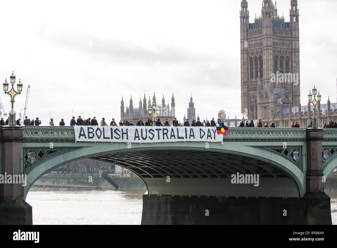London, UK. 25th January, 2019. Activists drop a banner from Westminster Bridge, in view of the Houses of Parliament, to call for the abolition of Australia Day in advance of rallies in every Australian city tomorrow. The event was organised in solidarity with Aboriginal and Torres Strait Islander people who consider Australia Day, a day celebrating the colonisation of Australia, to be a day of mourning rather than a day of celebration. Credit: Mark Kerrison/Alamy Live News Stock Photo