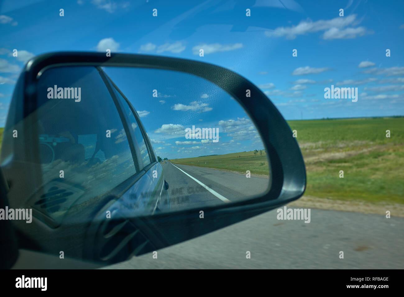 Blue cloudy sky landscape sunset reflect in mirror of car during the