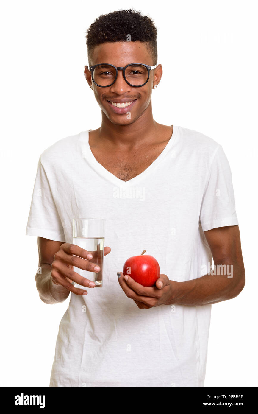 Young happy African man holding red apple and glass of water Stock ...