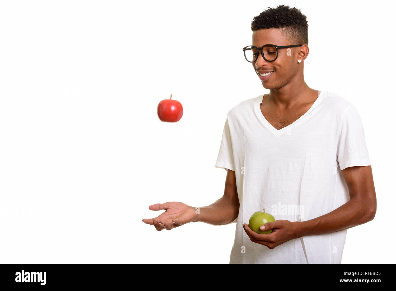Young happy African man holding red and green apple Stock Photo - Alamy