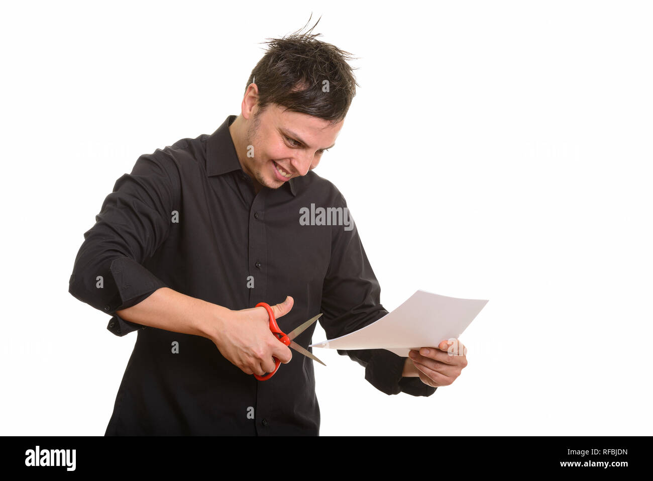 Studio shot of crazy Caucasian businessman cutting paper Stock Photo