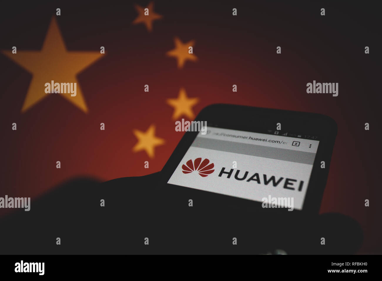 Huawei logo on its website is shown on a smartphone display, People's Republic of China flag unfocused on background Stock Photo
