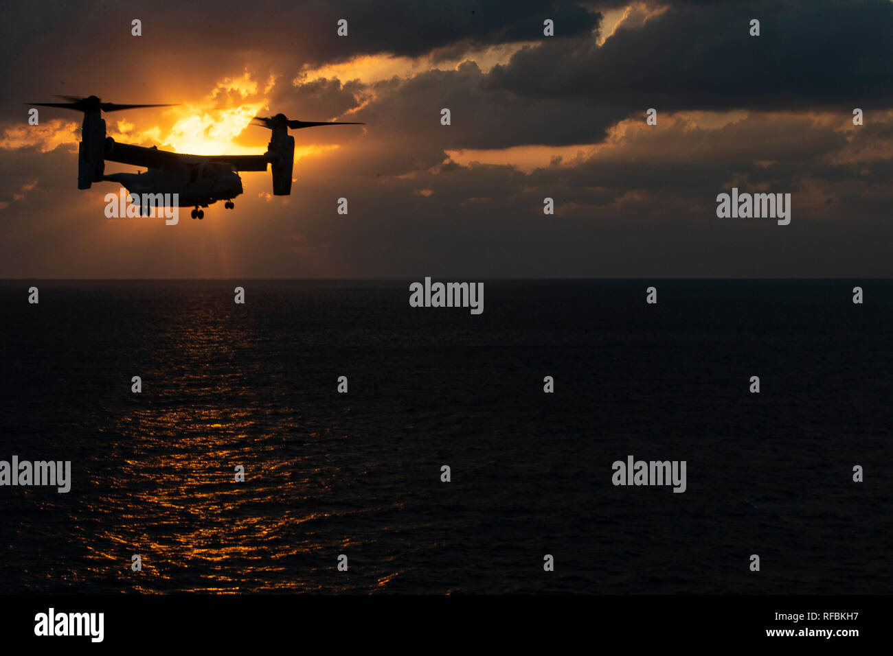 An MV-22B Osprey tiltrotor aircraft belonging to Marine Medium Tiltrotor Squadron 262 (Reinforced) approaches the amphibious assault ship USS Wasp (LHD 1) during flight operations underway in the Philippine Sea, Jan. 23, 2019. Naval aviators with VMM-262 (Rein.), the tiltrotor component of the 31st Marine Expeditionary Unit's Aviation Combat Element, perform a wide variety of aviation missions for the 31st MEU, including troop transport, heavy and medium lift, fixed-wing attack support and aerial reconnaissance. The 31st MEU, the Marine Corps’ only continuously forward-deployed MEU partnering Stock Photo