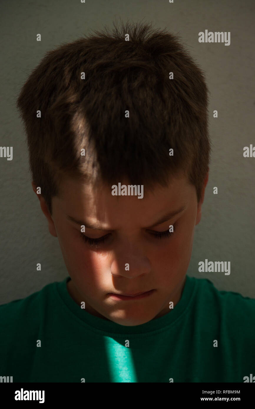 Shaft Of Light On The Face Of A 7 Year Old Boy With Short Brown