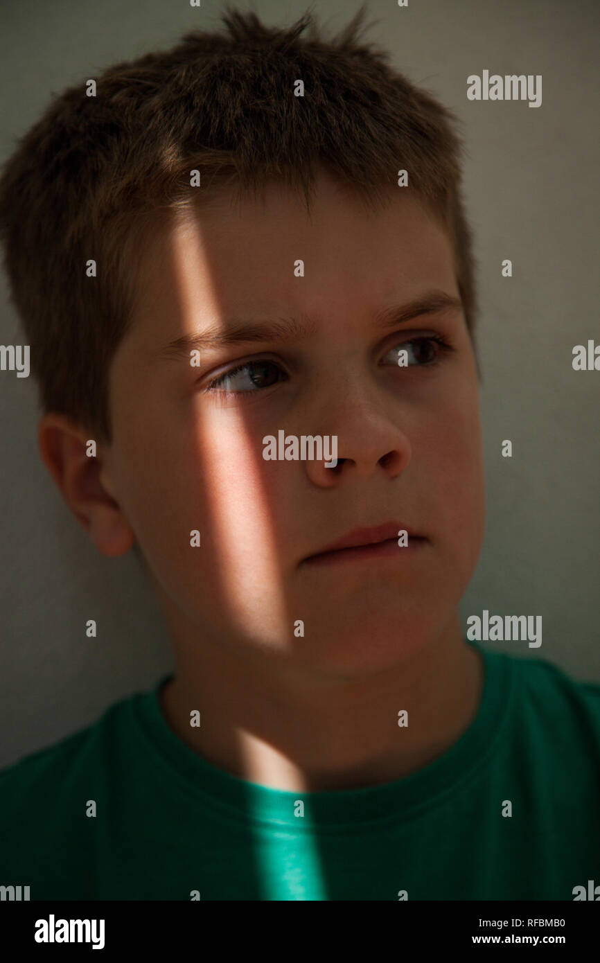 Shaft Of Light On The Face Of A 7 Year Old Boy With Short Brown
