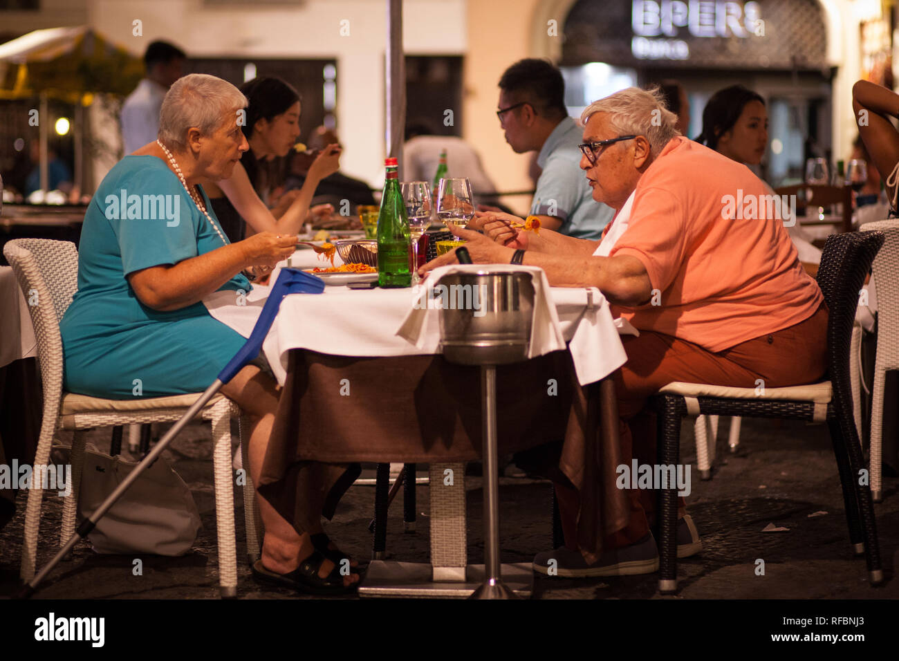 Elderly couple eating dinner outside in the piazza, Amalfi, Italy Stock Photo