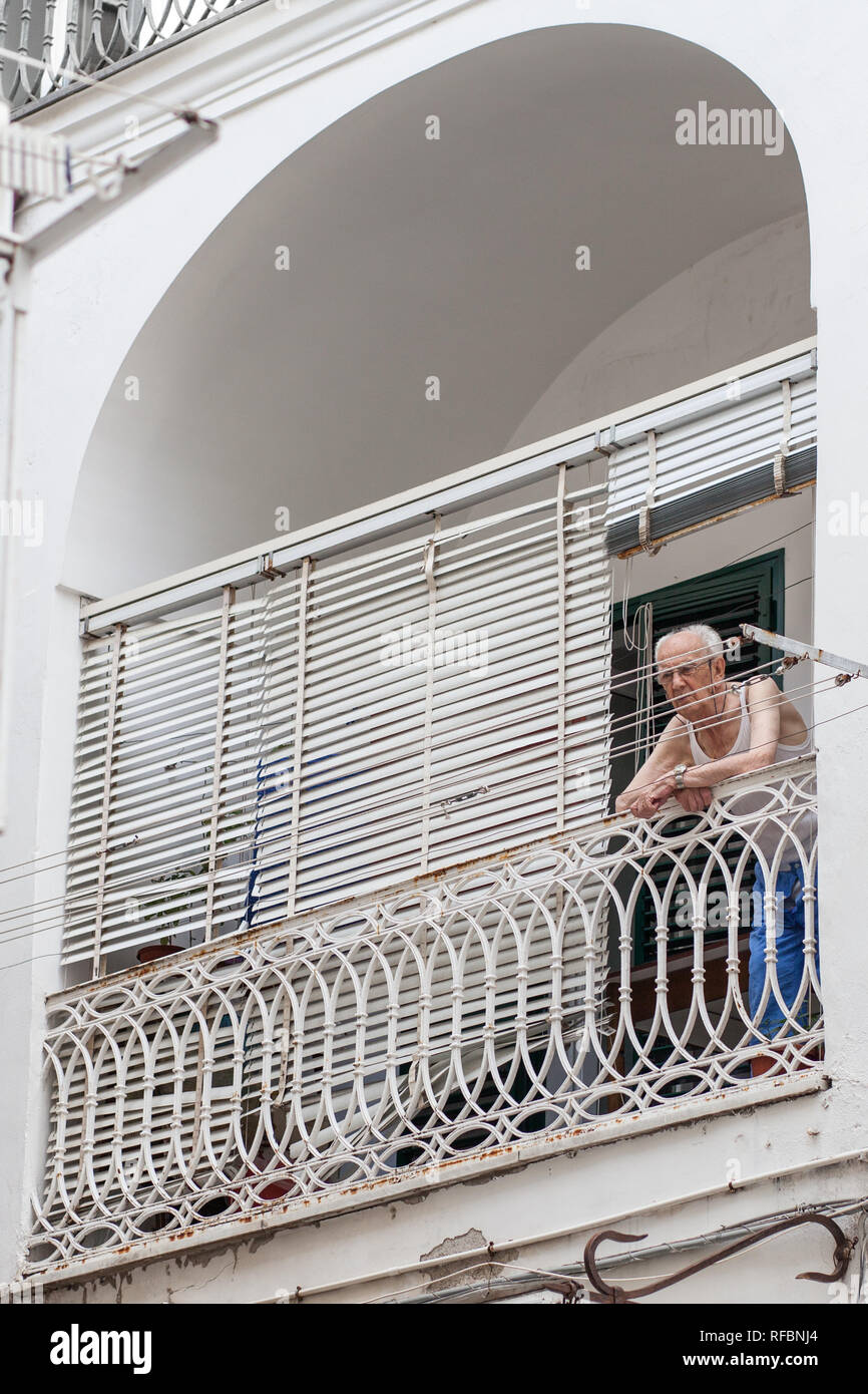 Elderly man leaning over balcony in Amalfi, Italy Stock Photo