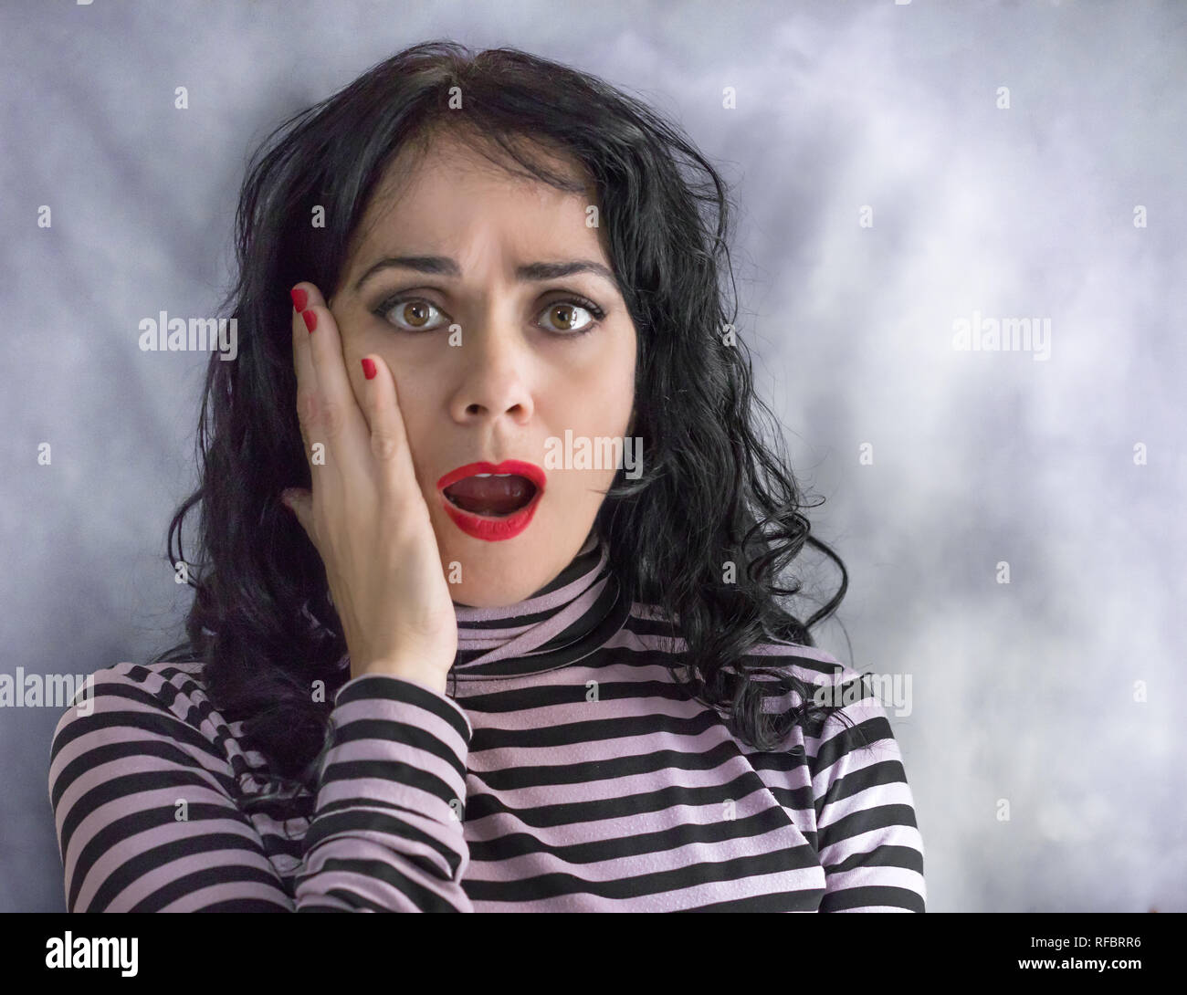 Adult hispanic woman over isolated background afraid and shocked with surprise expression, fear and excited face Stock Photo