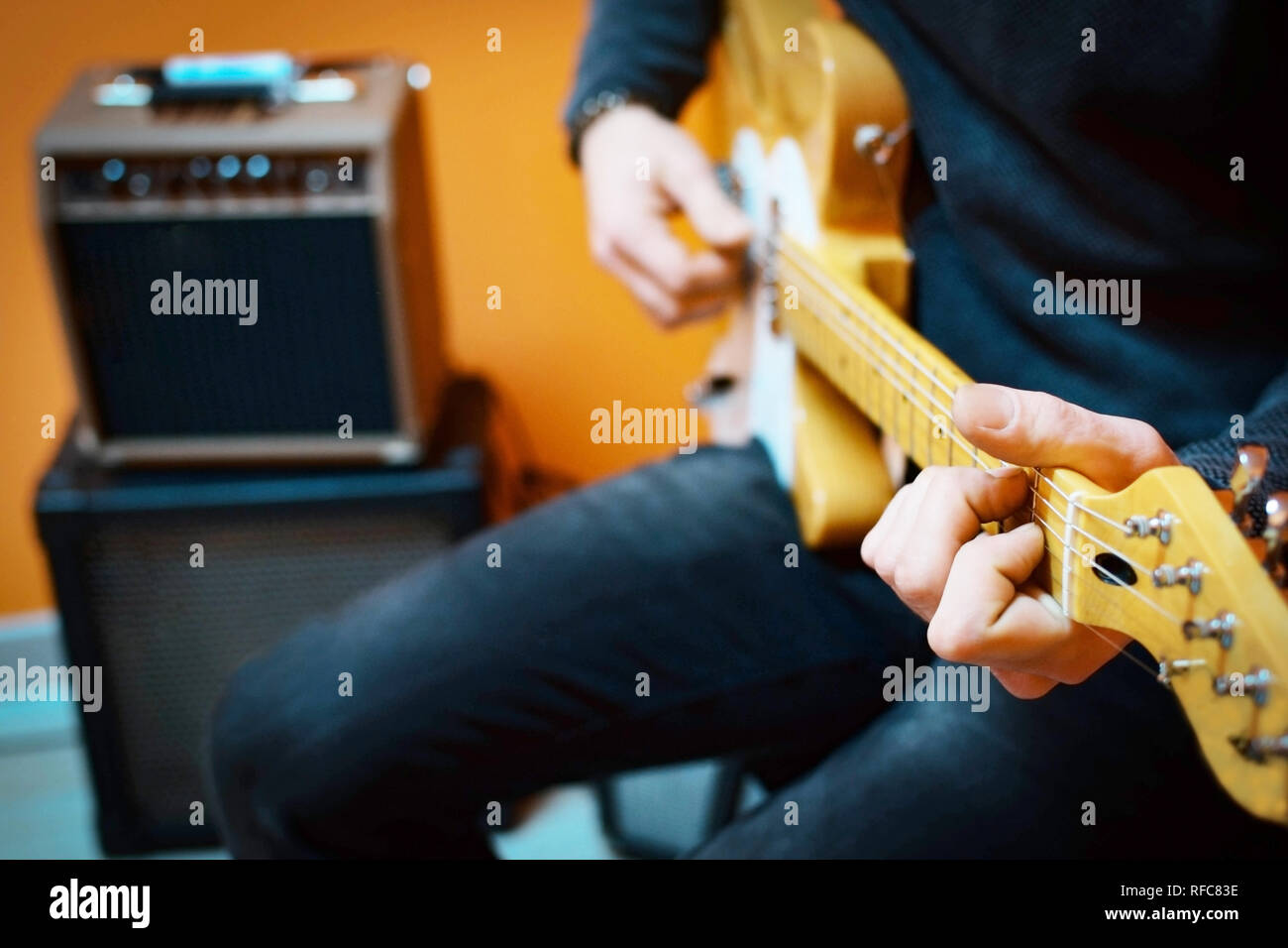 Man practicing electric guitar playing with amplifiers at home. Guitar lesson. Trying guitar at store. Stock Photo