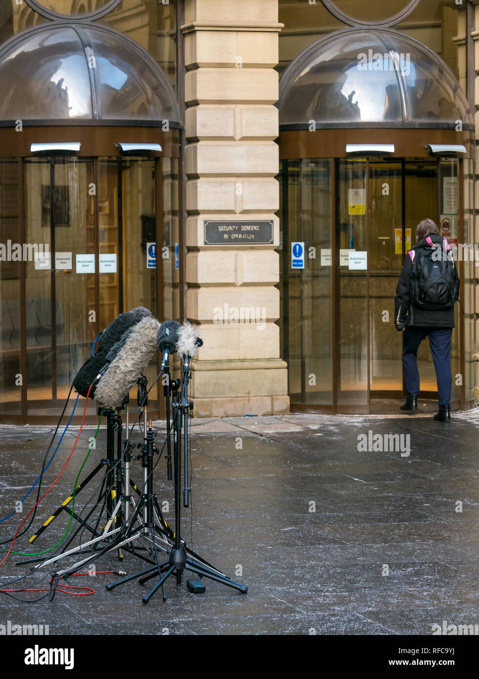 Edinburgh Sheriff Court with press microphones and person entering door