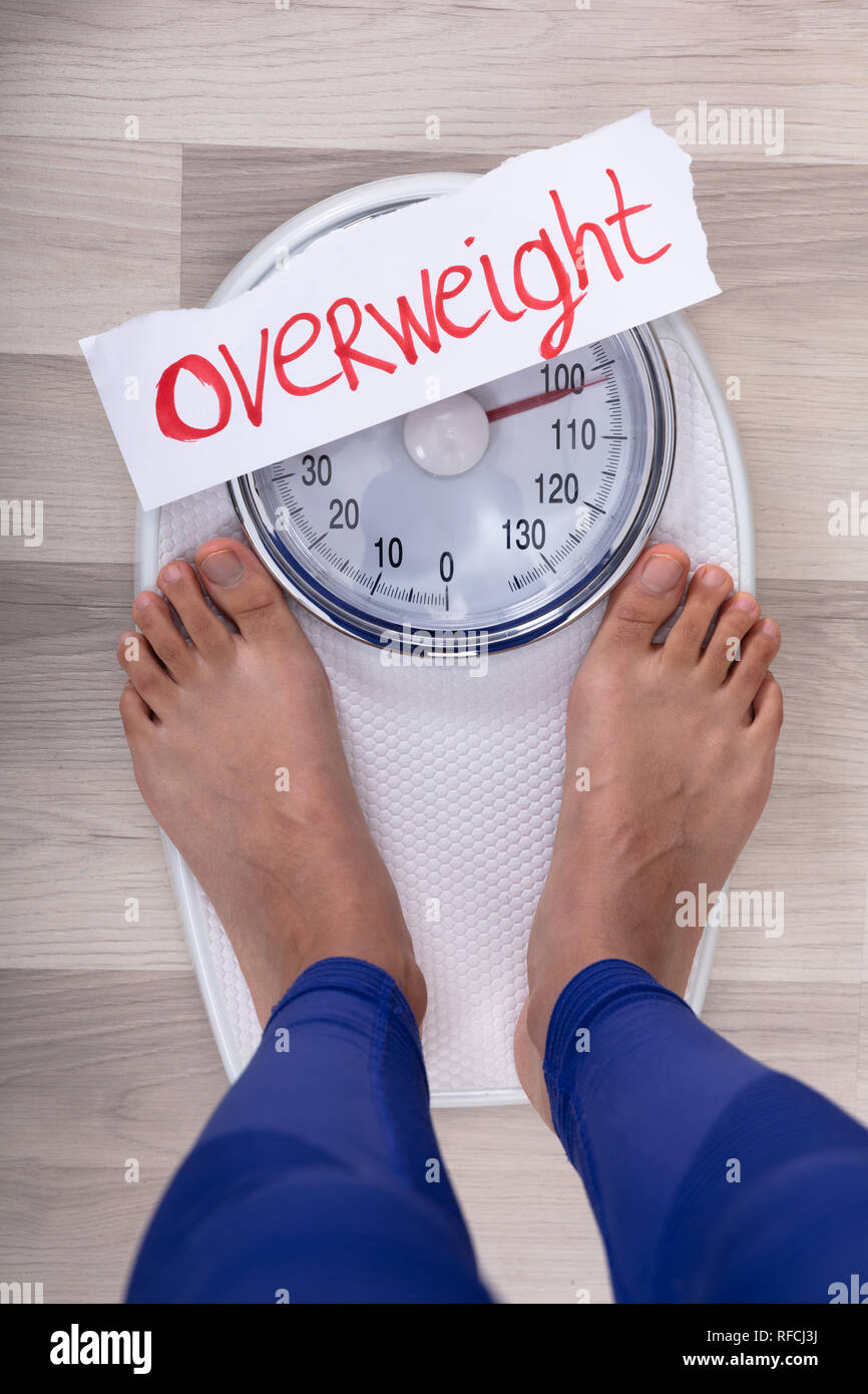 https://c8.alamy.com/comp/RFCJ3J/close-up-of-womans-feet-on-weighing-scale-indicating-overweight-on-white-paper-RFCJ3J.jpg
