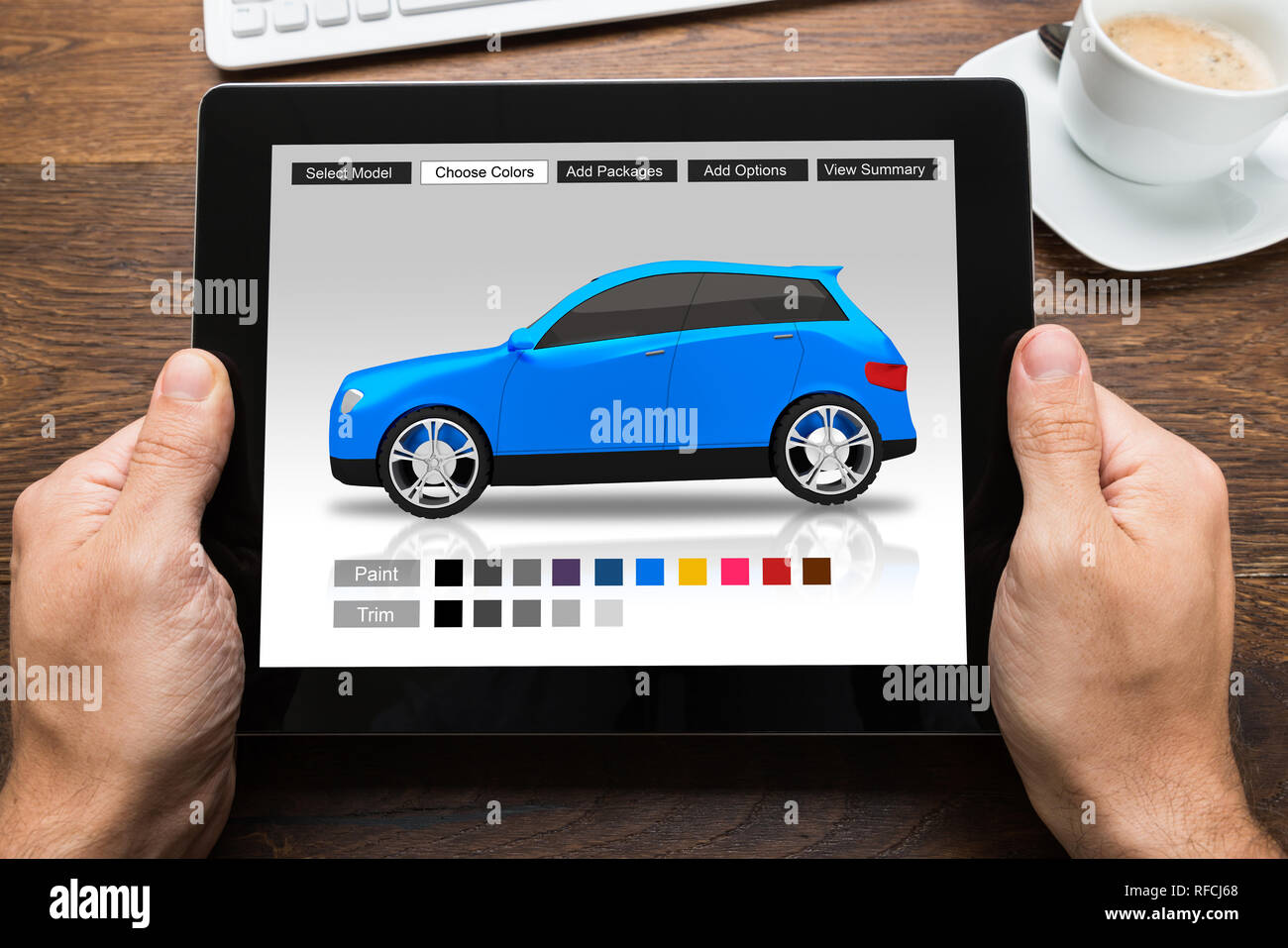 Close-up Of A Person Choosing Car's Color On Digital Tablet Over Desk Stock Photo