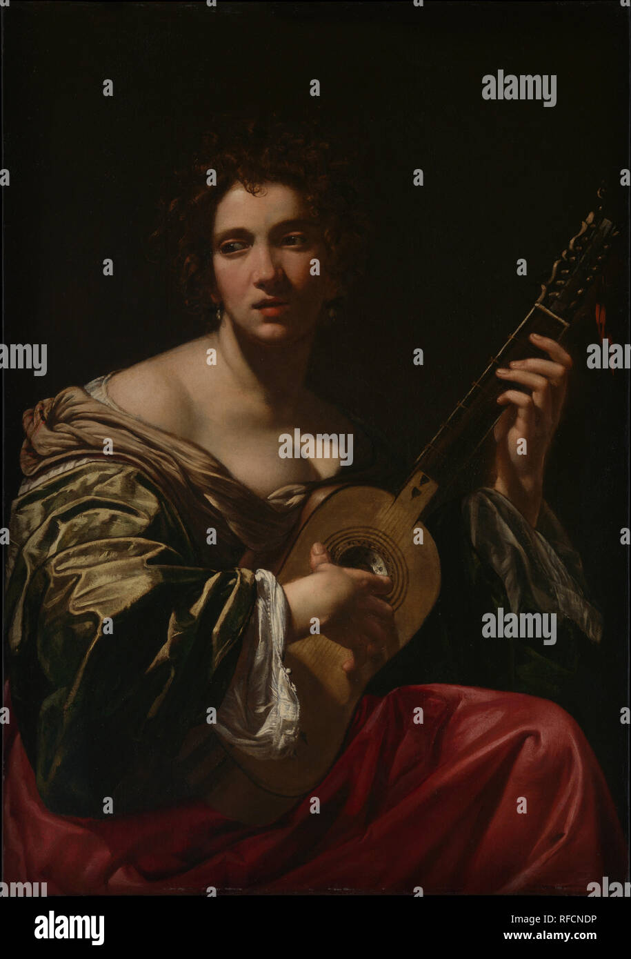 Woman Playing a Guitar. Artist: Simon Vouet (French, Paris 1590-1649 Paris). Dimensions: 42 × 29 7/8 in. (106.5 × 75.8 cm). Date: ca. 1618.  This alluring depiction of a woman playing a guitar was painted during Vouet's years in Rome and reveals his interest in the work of Caravaggio with its dramatic lighting and psychological engagement with the beholder. Women playing guitars have a long history in European painting. Seventeenth-century French engravings of modes and manners often show them, as here, lost in reverie. One, dated 1630, has the caption 'Love Conquers All but Music Does Not Con Stock Photo