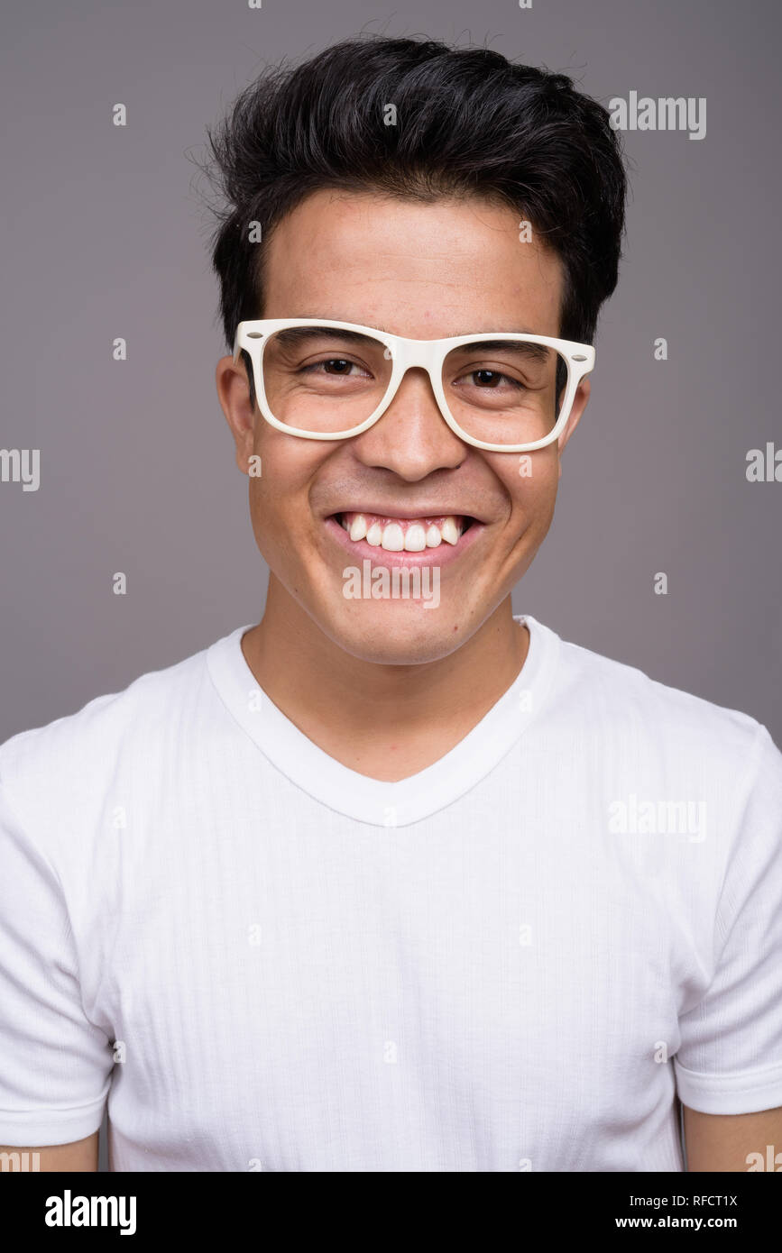 Portrait of young Asian man against gray background Stock Photo - Alamy