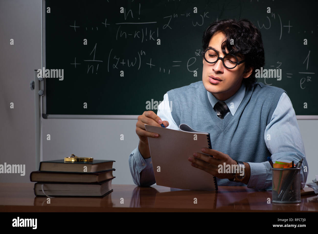 Young math teacher in front of chalkboard Stock Photo