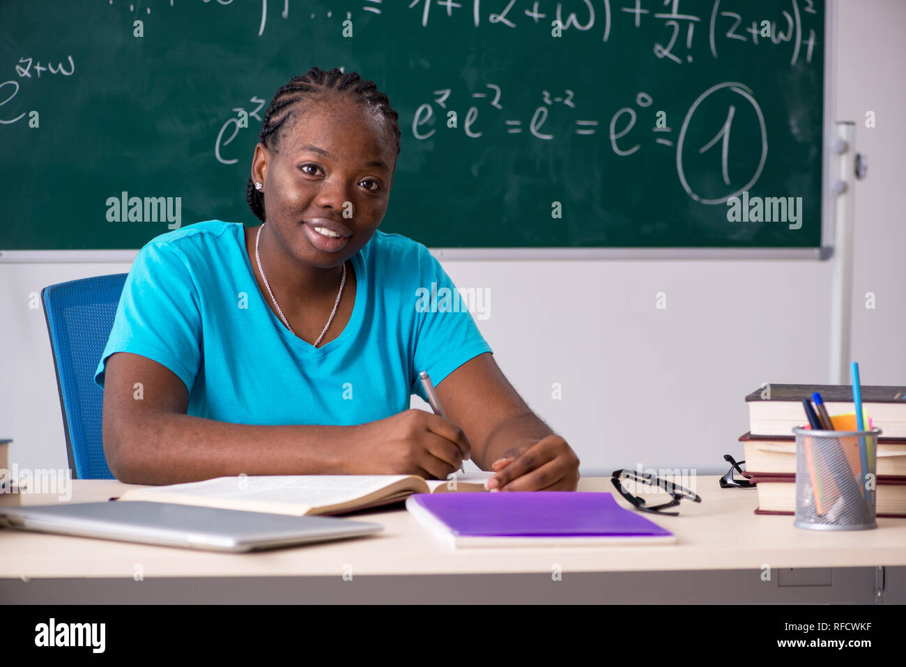Black female student in front of chalkboard Stock Photo - Alamy