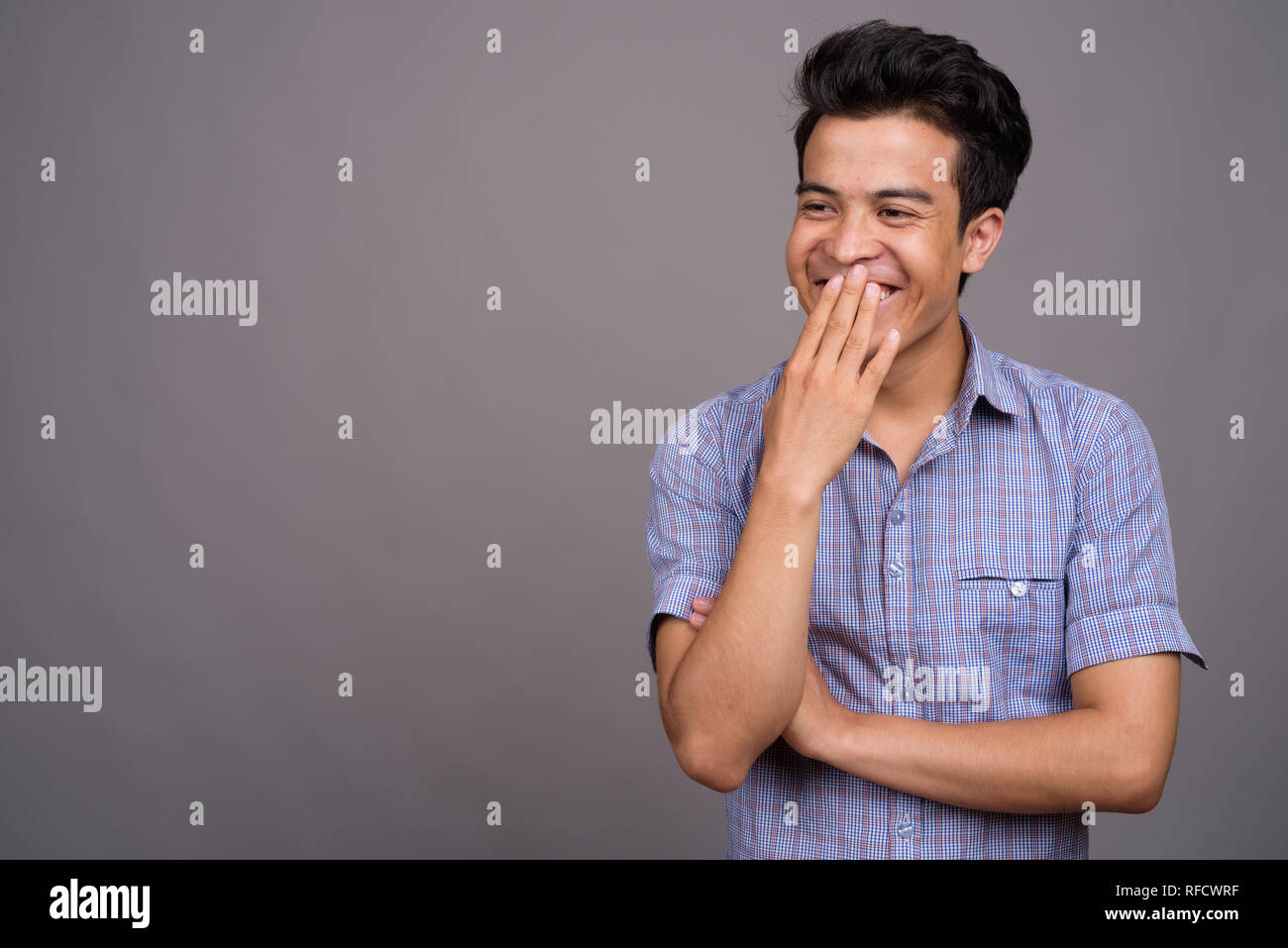 Portrait of young Asian businessman against gray background Stock Photo