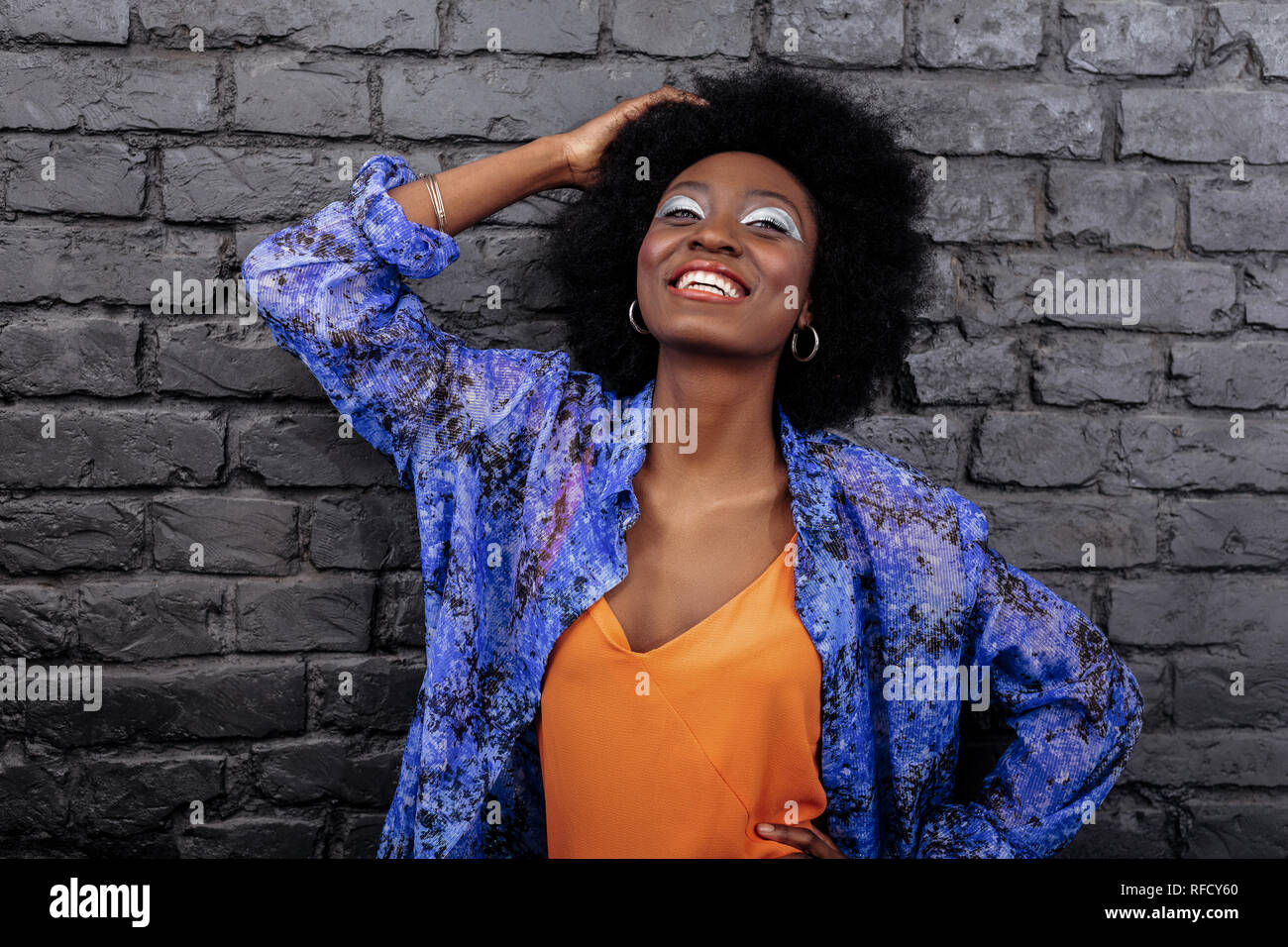 Dark-haired beautiful model with big earrings smiling brightly Stock Photo