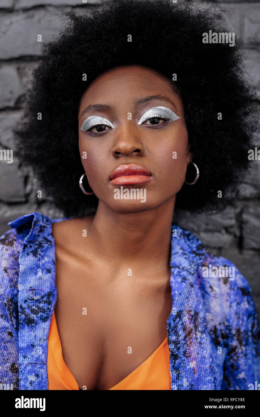Dark-haired beautiful model with bright makeup looking serious Stock Photo