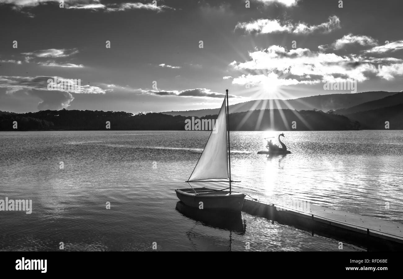 Lonely Sailboat In The Beautiful Sunset With Sun Stars Shines From Sky And The Surface Of The Lake Is Calm And Peaceful When Watching Them Stock Photo Alamy