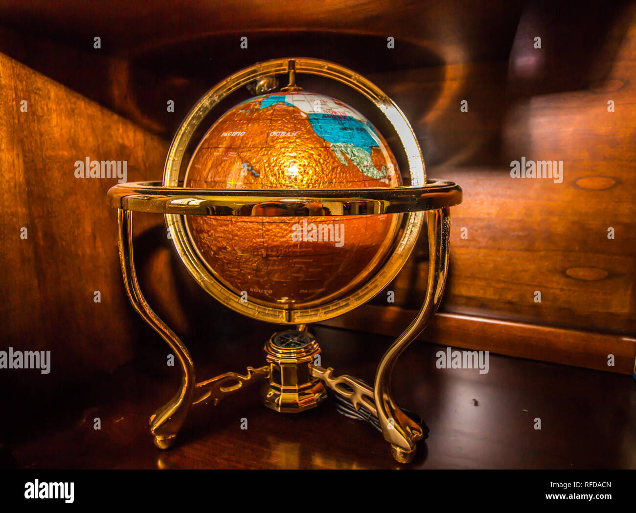 Colorful Globe In Gold Stand Against Wood Background Stock Photo Alamy