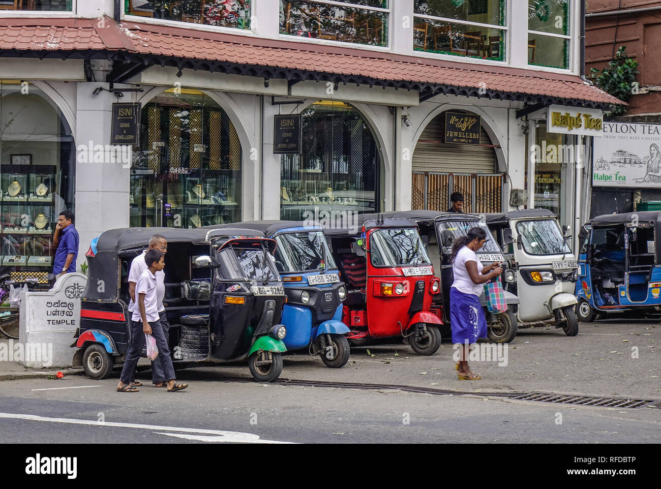 Kandy, Sri Lanka - Dec 15, 2018. People and tuk tuk taxis on street in Kandy, Sri Lanka. Tuk tuk used to be everyone favourite way of getting around K Stock Photo