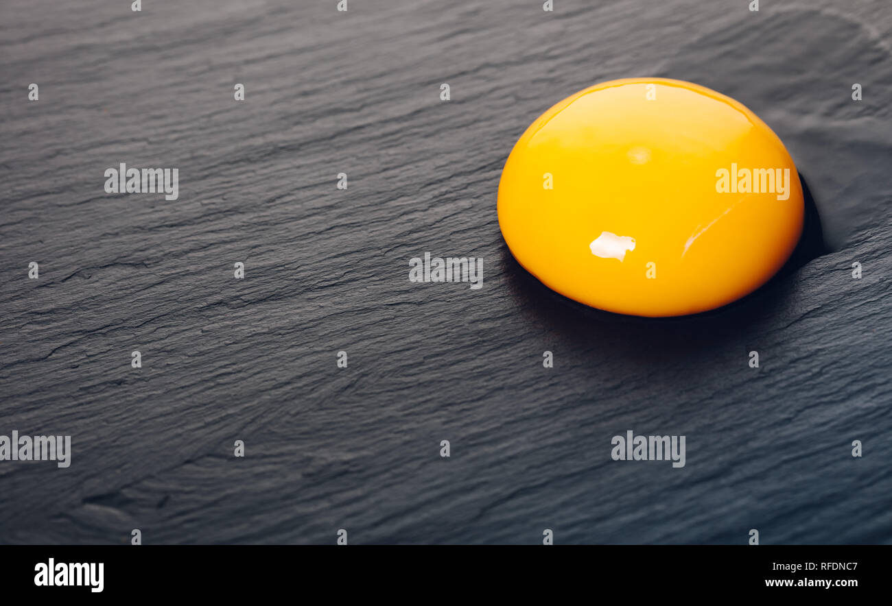 chicken egg yolk closeup on black stone background Stock Photo Alamy