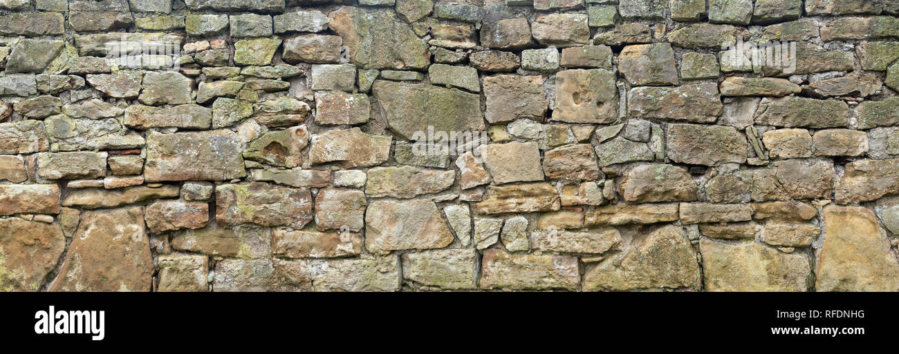 Rough, very old natural stone wall Stock Photo