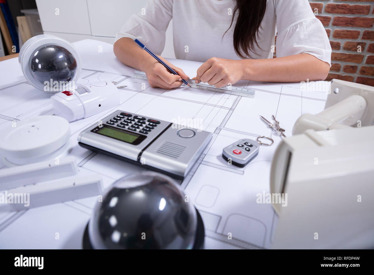 Close-up Of A Female Architect Drawing Blueprint With Pencil On Desk In The Office Stock Photo