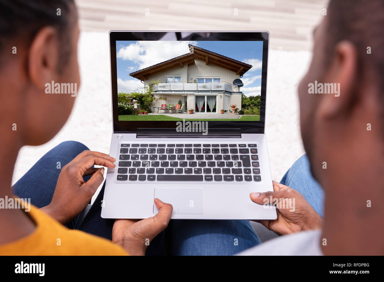Close-up Of A Couple Looking At New House On Laptop Stock Photo