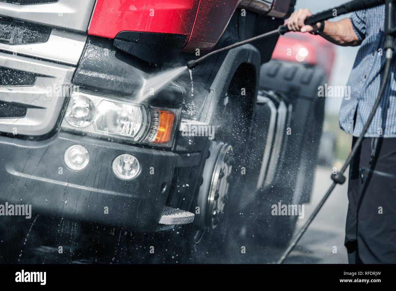 Semi Truck Pressure Washing by Caucasian Trucker. Automotive and