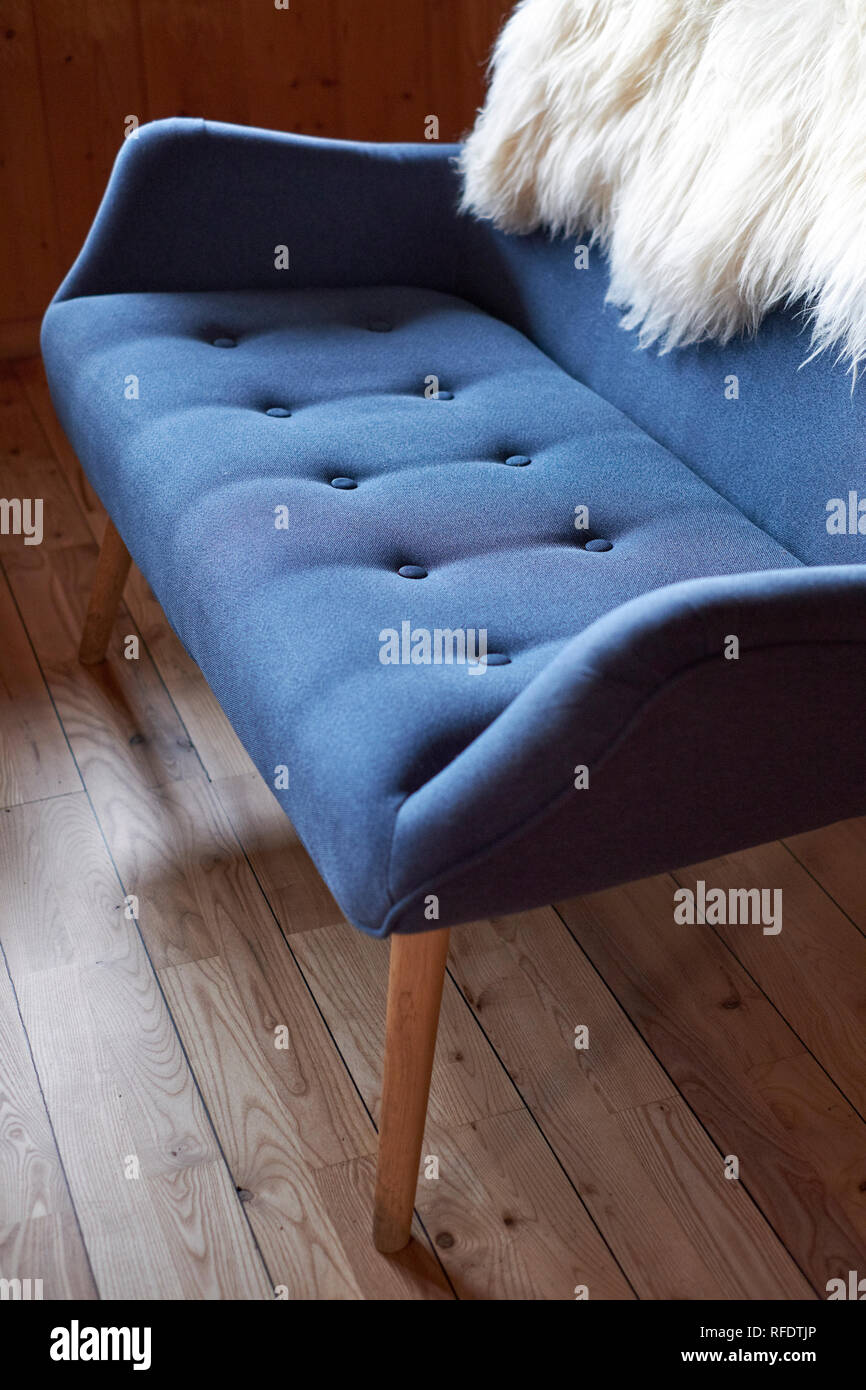 A blue fabric retro scandinavian sofa design with a fleece throw. Stock Photo