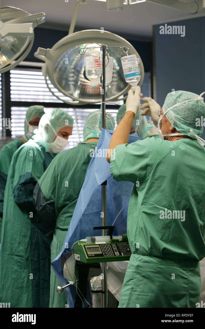 Operating room , anaesthesia assistant changing infusion bag Stock