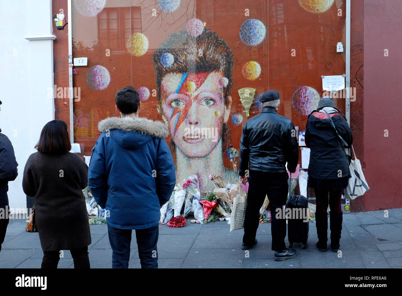 People looking at David Bowie mural in Brixton, London Stock Photo