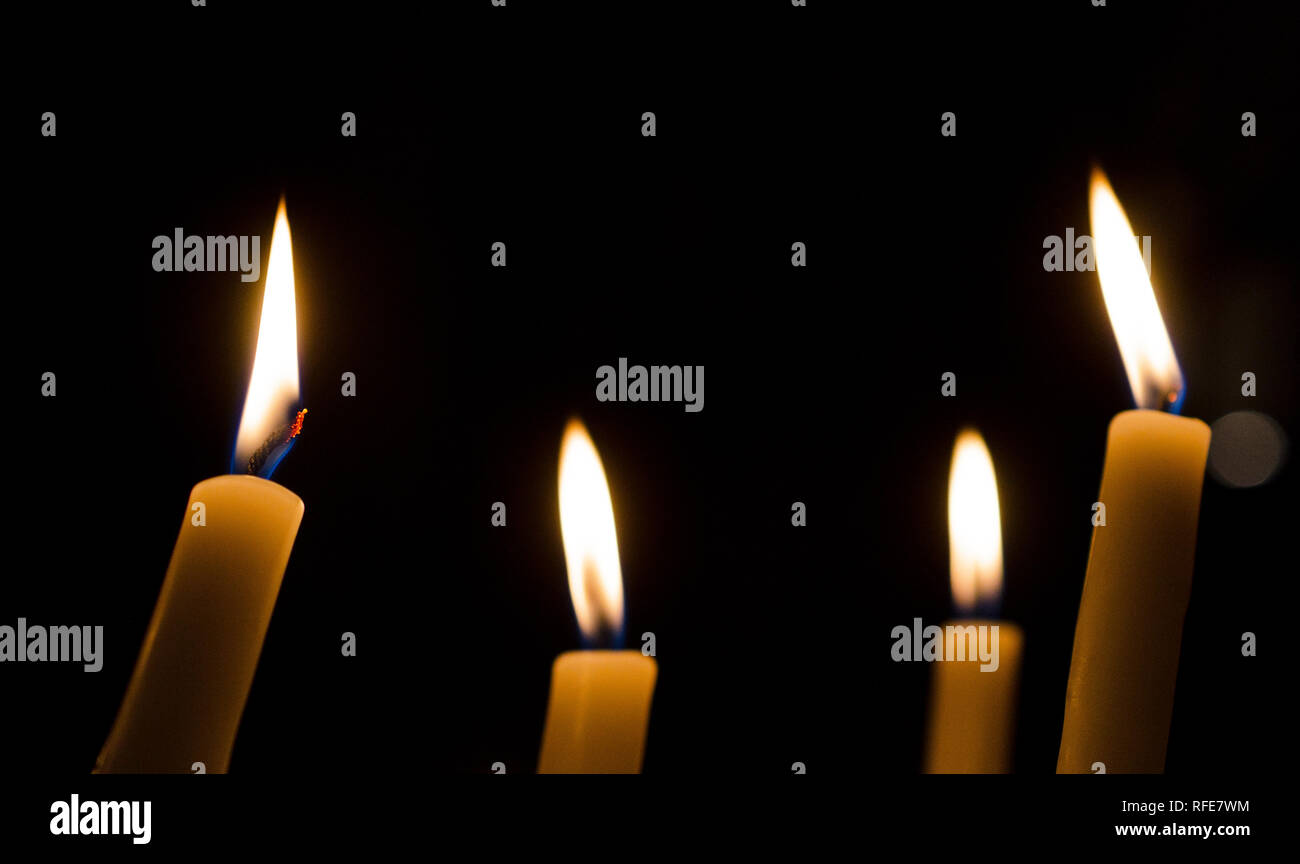 Four candles shine in the dark Stock Photo Alamy