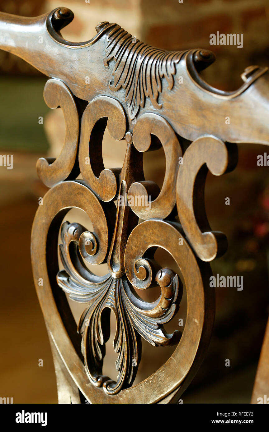 Ornately carved wooden chair back in oak colour Stock Photo