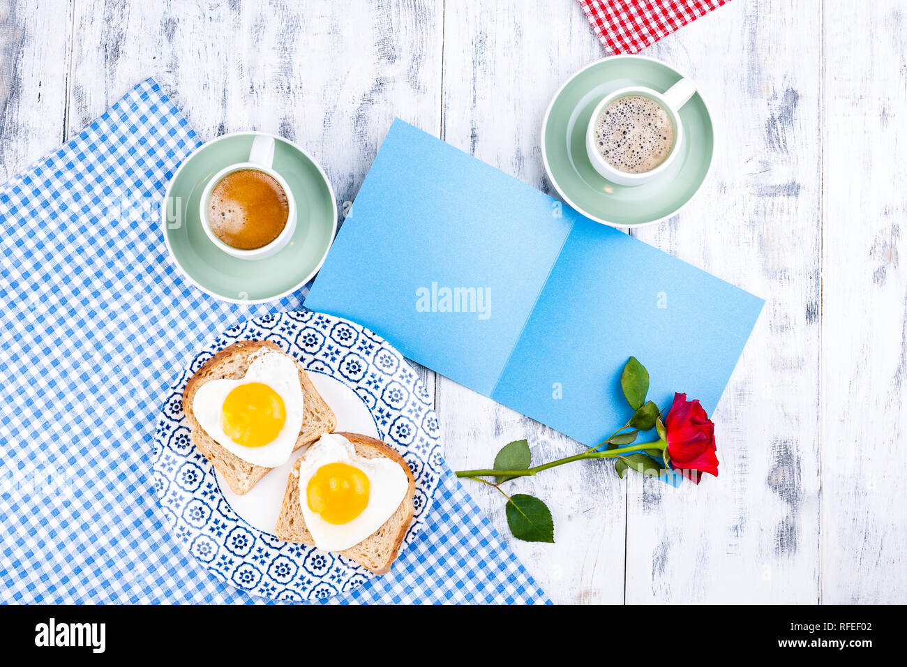 Flowers, Two cups of aromatic coffee and heart-shaped toasts for a romantic morning of lovers. Red rose, letter or note on the table. The concept of V Stock Photo