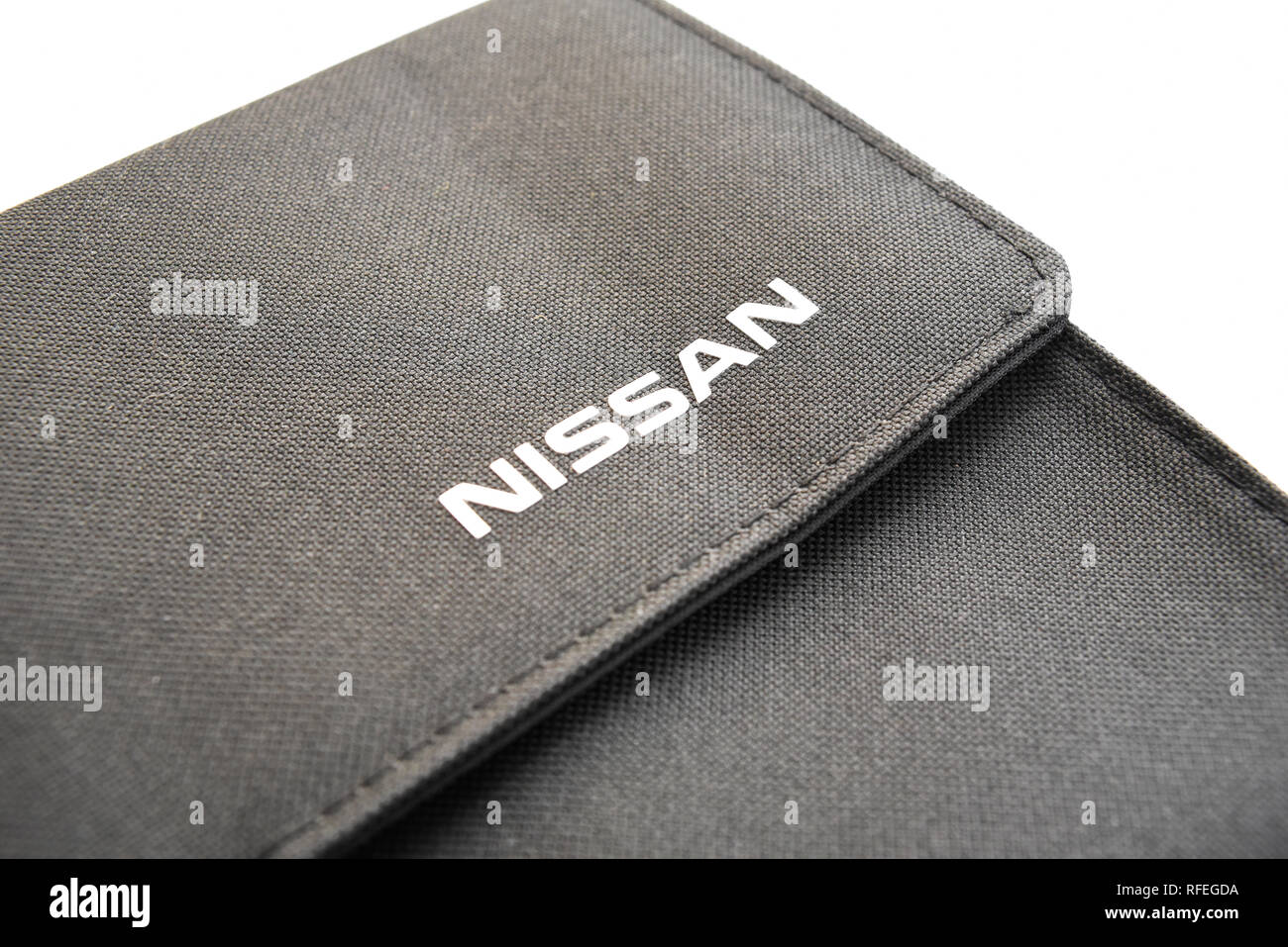Nissan branded fabric wallet for paperwork. Motor car manufacturer. Nissan brand on folder. Japanese vehicle motoring company logo. Isolated Stock Photo