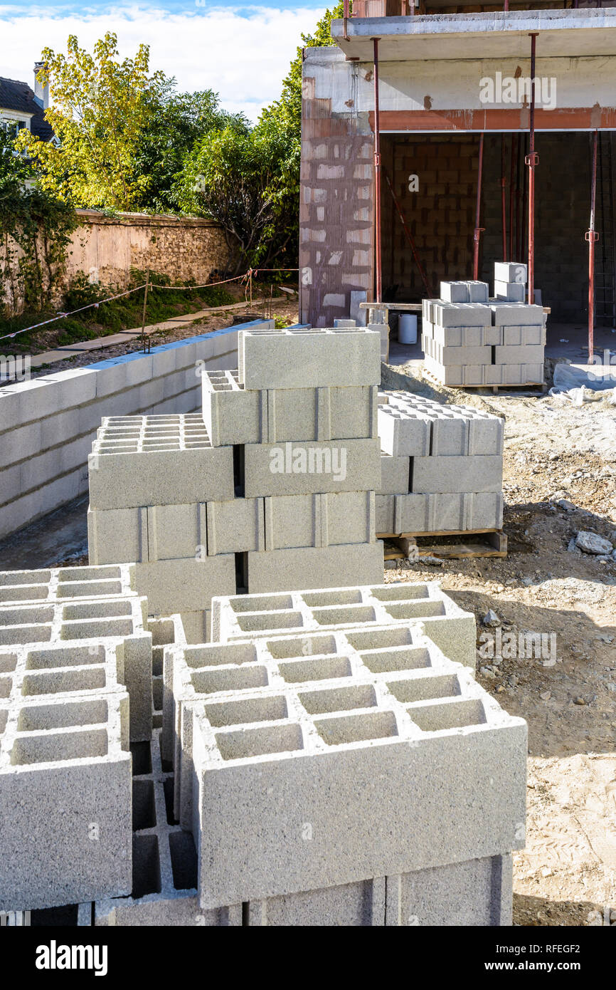Concrete Blocks Stacked On Pallets Outdoors In Front Of A Detached 