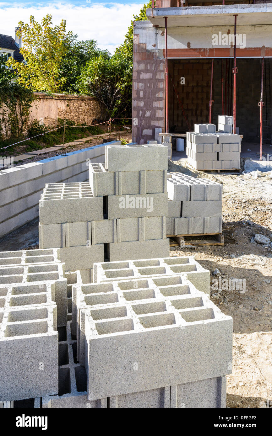 Concrete blocks stacked on pallets outdoors in front of a detached house under construction in the suburbs of Paris, France. Stock Photo