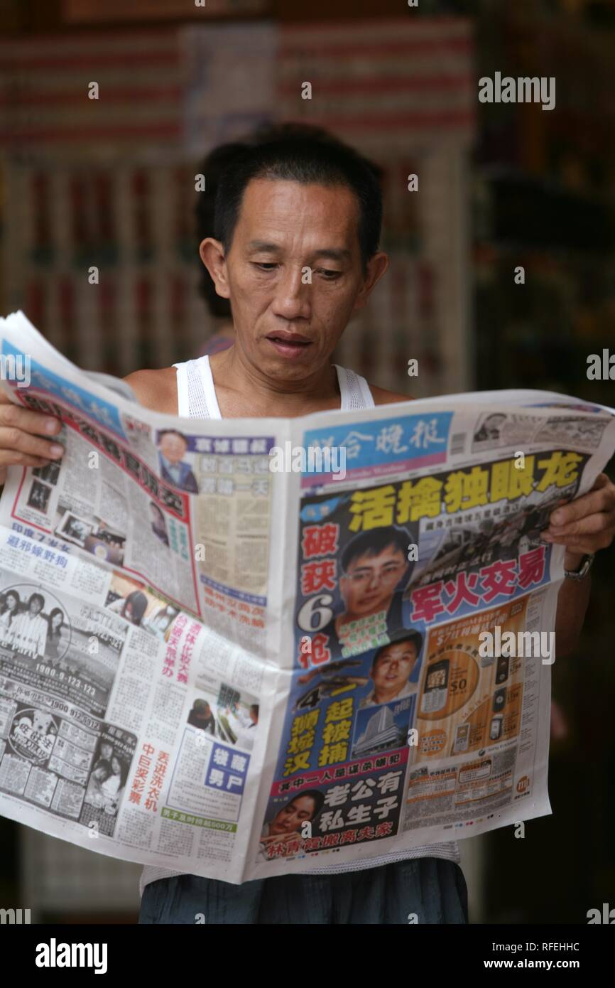 SGP, Singapore: Newspaper reader. | Stock Photo